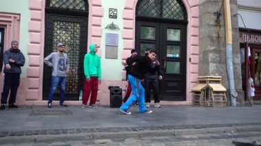 LVIV, UKRAINE - 28 Ağustos 2019: Bilinmeyen adamlar şehrin sokaklarında dans molası veriyor. Yavaş çekim.