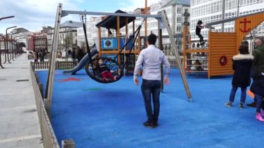 LA CORUNA, İSPAN - 2 Nisan 2018: Şehir parkındaki çocuklar. La Coruna İspanya 'nın kuzeybatısındaki büyük şehir, tatil köyü ve liman. Yavaş çekim.