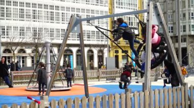 LA CORUNA, İSPAN - 2 Nisan 2018: Şehir parkındaki çocuklar. La Coruna İspanya 'nın kuzeybatısındaki büyük şehir, tatil köyü ve liman. Yavaş çekim.