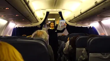 KIEV, UKRAINE - 23 Mart 2018: Boryspil Uluslararası Havaalanı. Hostes, yolculardan önce personel güvenliği bildirimi yapar..