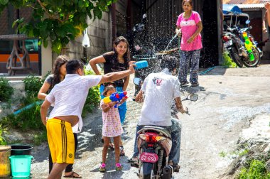 Patong, Phuket, Tayland - 13 Nisan 2014. Songkran Festivali. Genç Taylandlılar bisikletle geçerken su dökerler.