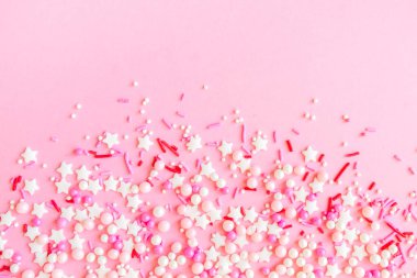 Renkli pastel renkli çerçevelerden yapılmış, pembe arka planda serpiştirilmiş, üstünde de fotokopi alanı var. Top ve yıldızlı şekerleme, pasta ve fırın ürünleri için dekorasyon. Üst görünüm veya düz uzanma