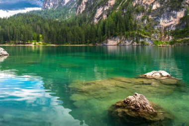 Braies 'in sihirli gölü. Zümrüt su kütlesi etrafındaki ormanı ve dağları yansıtır. Güney Tyro. İtalya. Avrupa