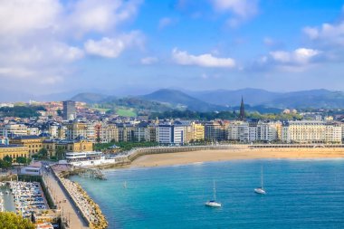 İspanya 'nın Bask Bölgesi, Biscay Körfezi' ndeki Donostia San Sebastian şehir merkezindeki kumlu sahil ve marinanın güzel gün batımı manzarası..