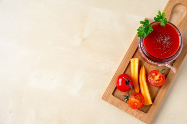 Cam bir kavanozda maydanoz yapraklı domates püresi ve hazırlamak için gerekli malzemeler. Taze domates, havuç, ahşap arka planda maydanoz. Boşluğu kopyala.