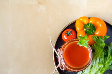 Cam bir kavanozda domates püresi ve hazırlamak için gerekli malzemeler. Taze domates, dolmalık biber ve siyah tabakta marul. Ahşap arka plan. Boşluğu kopyala.