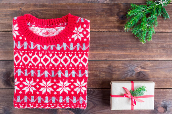 Верхний вид рождественский свитер, подарки и ветки елки на деревянном фоне. Пространство для размещения и копирования
.