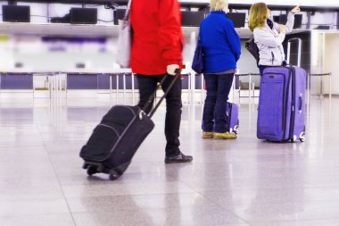 Havaalanına giden yolcuların bavulları uçuş saatlerini gösteriyor.