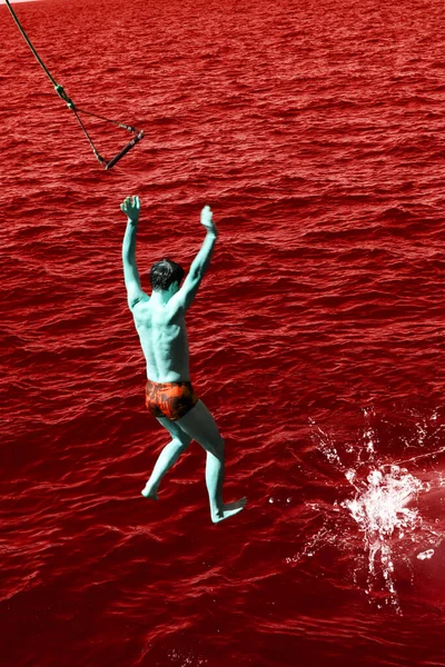 man jumping with balsa in the atlantic ocean in a circle of spray