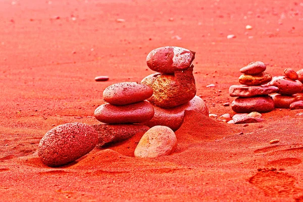 well-balanced stones in the sand on coral background