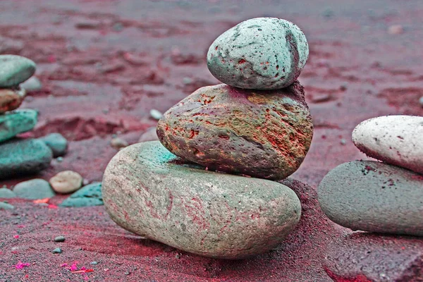 balance of wet volcanic stones in a pinkish background