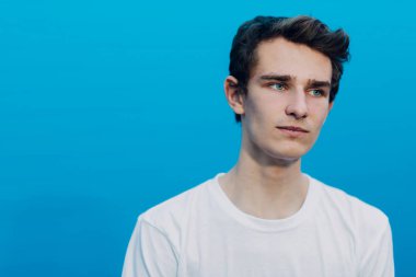 Mavi arka planda yakışıklı bir adamın portresi.