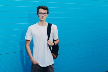 Mavi arka planda sırt çantalı öğrenci