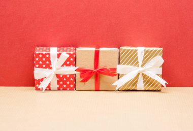 Kırmızı kağıt arka plan üzerinde Noel hediyeleri
