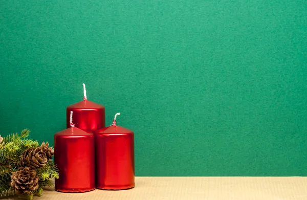 Three red candles on green background — Stock Photo, Image