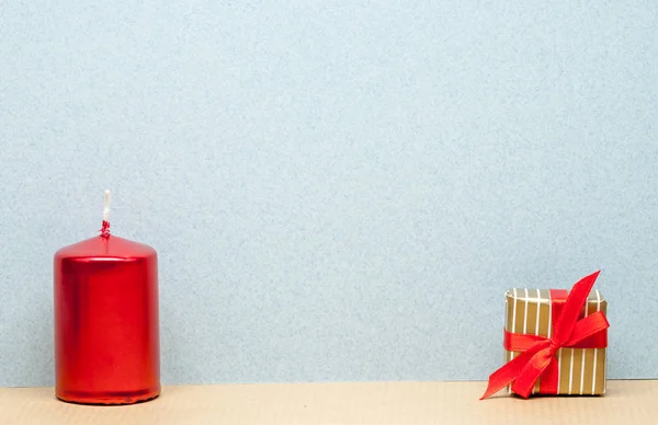 One red candle and small gift — Stock Photo, Image