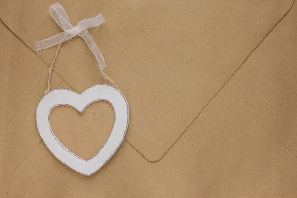 Trä hjärta på kuvertet bakgrund — Stockfoto