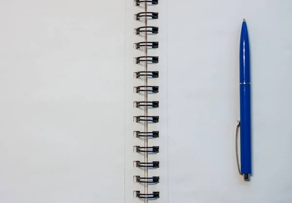 Caderno branco em branco e caneta azul — Fotografia de Stock