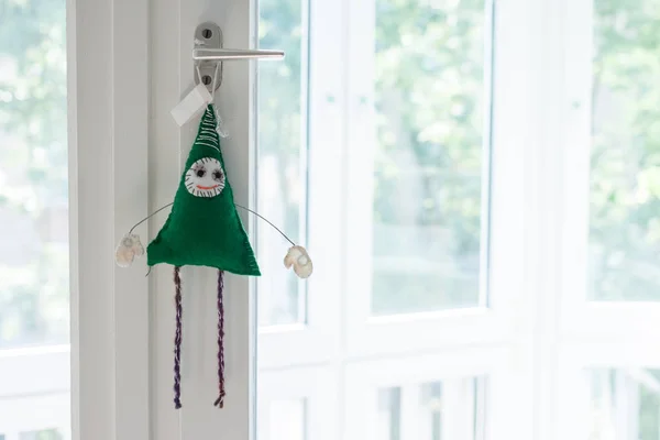Handmade toy green creature on window — Stock Photo, Image