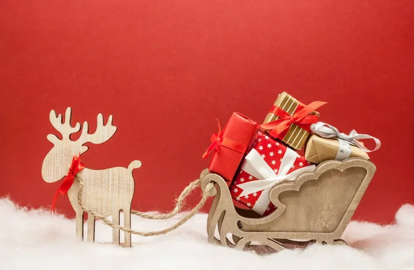 Weihnachtshirsch mit Schlitten und Geschenken — Stockfoto