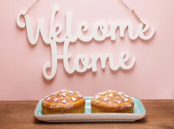 Dos pasteles festivos bajo palabras de bienvenida — Foto de Stock