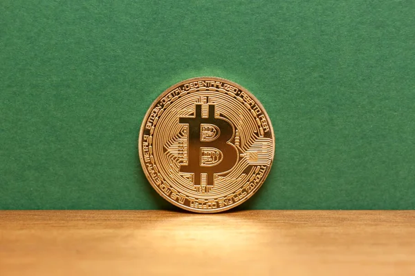 Золотий bitcoin монету, зелений фон — стокове фото
