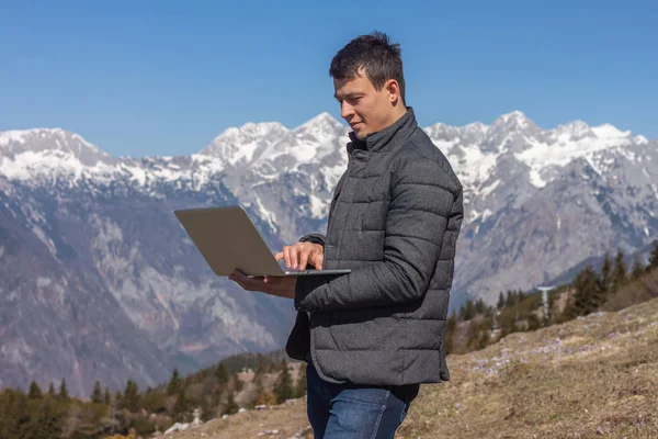 Joven freelancer utilizando portátil en las montañas — Foto de Stock