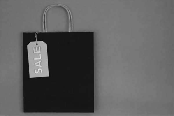 Saco de papel preto e branco com etiqueta de venda — Fotografia de Stock