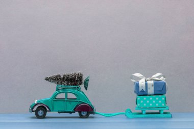 Noel hediyesi köknar ağacı olan yeşil oyuncak bir araba.