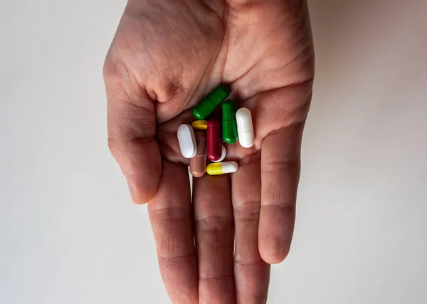 Main avec des pilules de différentes couleurs — Photo