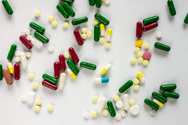 Pilules et capsules sur la surface de la table blanche — Photo