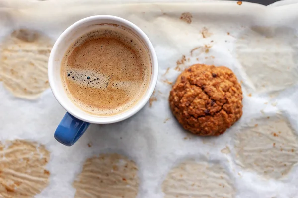 Biscuit à l'avoine et tasse de café sur papier cuisson — Photo