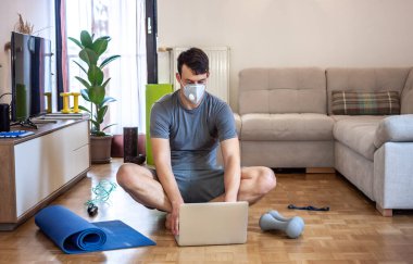 Adam karantinada çalışıyor ve evde egzersiz yapıyor.