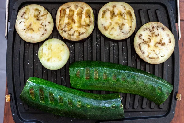 Zucchini and eggplant cooking on electric grill — Stock Photo, Image