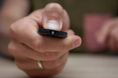 Erkek el uzaktan kumandayı tutar düğmeye bas