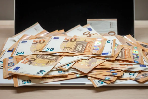 Aprire laptop e pile di banconote in euro — Foto Stock