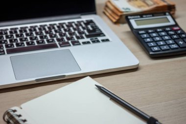 Dizüstü bilgisayarı ve nakit destesi olan ofis masası
