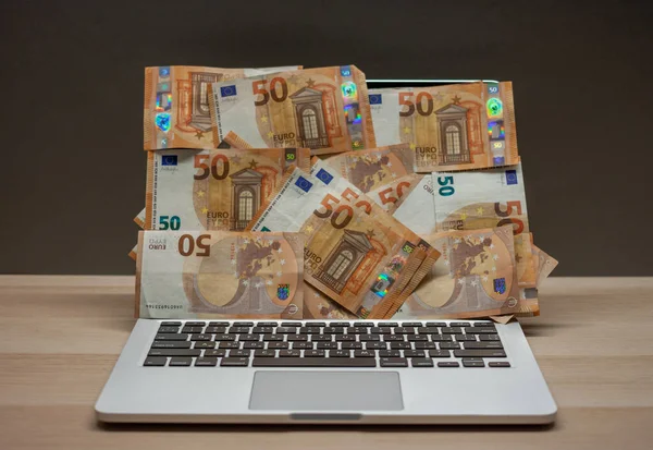 Otwarty laptop z ekranem pokrytym banknotami euro — Zdjęcie stockowe