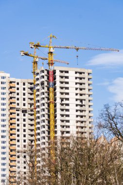 Yüksek katlı bir vinç ile bina inşaatı. Bina inşaat kalıp kullanarak. İnşaat Vinç ve mavi gökyüzü karşı bina