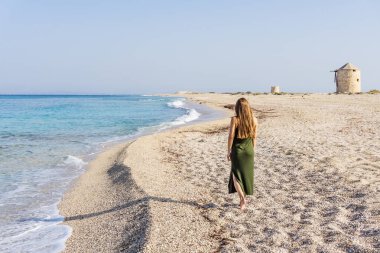 Yunanistan 'ın Lefkada adasındaki Ai Giannis (Gyra) plajında kadınlar güneşli bir günde yürüyor
