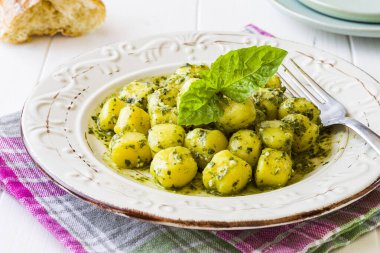 Beyaz ahşap zemin üzerinde 'Pesto' soslu Gnocchi.
