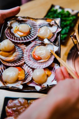 Lezzetli Asya yemeği ve deniz ürünleri hazırlayan kişinin kısmi görüntüsü