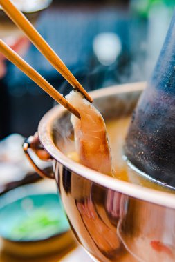 Yakın çekim yemek çubukları ve lezzetli bir tencere yemeği.