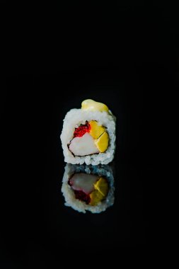 Japon yemeği mi? Siyah arka planda balık ve salatalıklı suşi rulosu. 