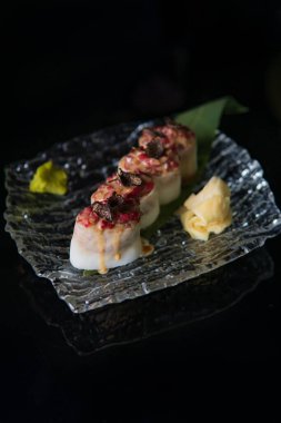 Siyah zemin üzerinde Japon dürümlerinin lezzetli görüntüsü.