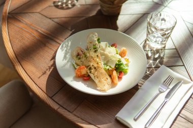 Restorandaki ahşap masada karidesli lezzetli Sezar salatasının yakın plan görüntüsü. 