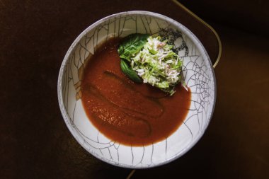 Tabağında maydanoz ve sebzeli kırmızı çorba manzarası  