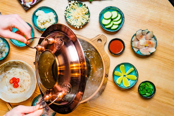 전통적 아시아 의뜨거운 그릇에 식탁에 재료를 그릇을 사람의 — 스톡 사진