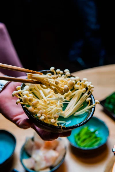 젓가락을 버섯으로 맛있는 아시아식 식사를 준비하는 사람들의 모습을 — 스톡 사진