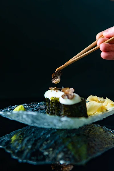 Sushi Łososiem Awokado Talerzu Przycięty Strzał Ludzkiej Ręki Pałeczkami — Zdjęcie stockowe